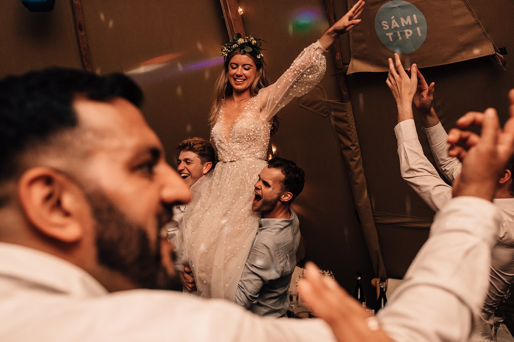 bride on shoulders at lively wedding party