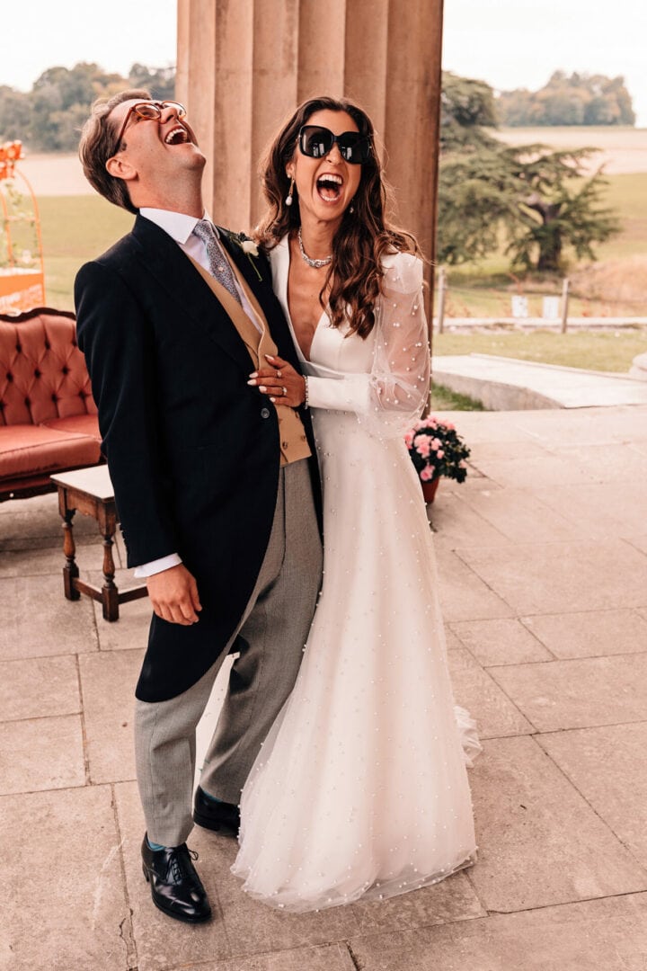 Stylish bride and groom laughing on their wedding day at The Grange in Hampshire