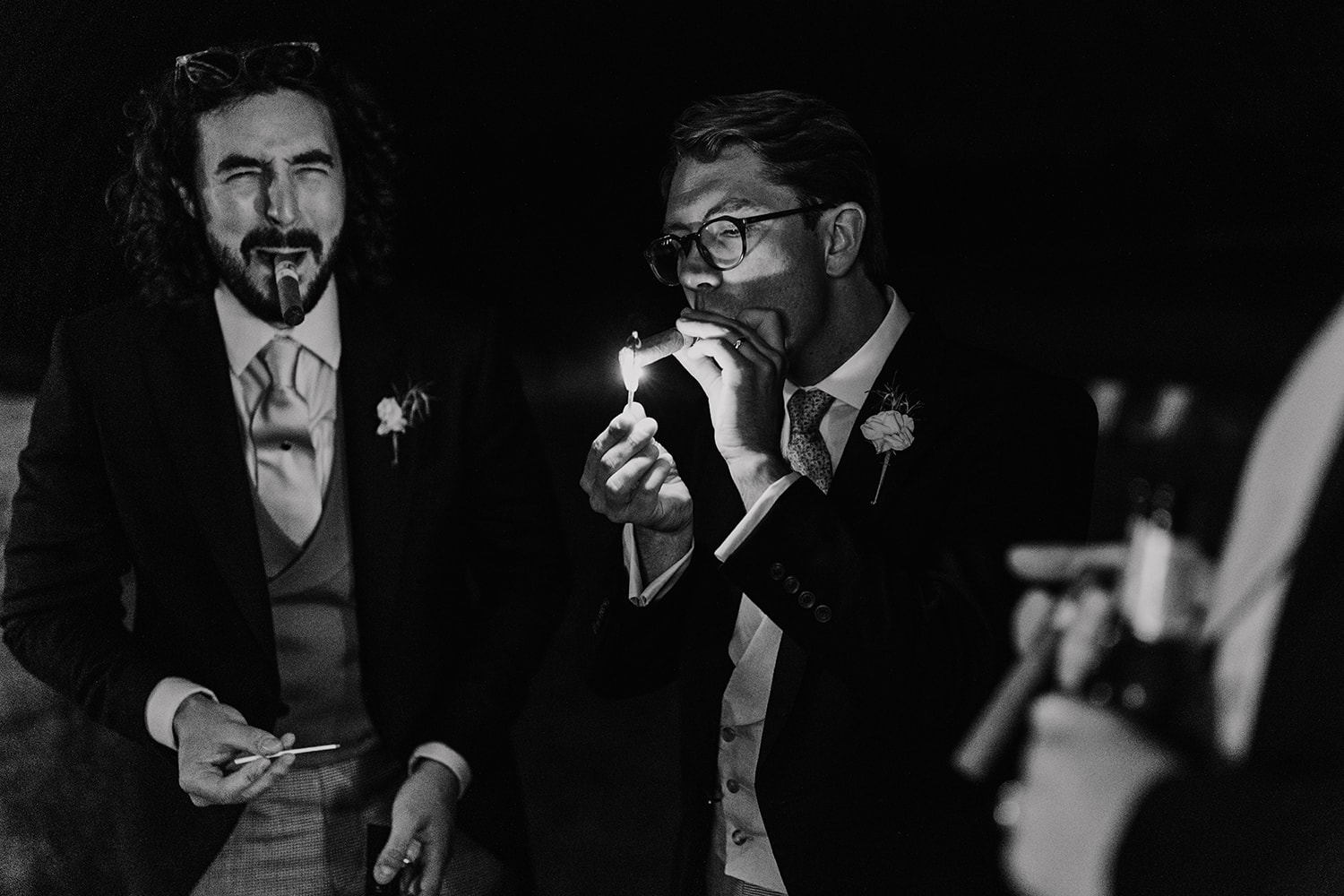 Black and white image of the Groom smoking a cigar