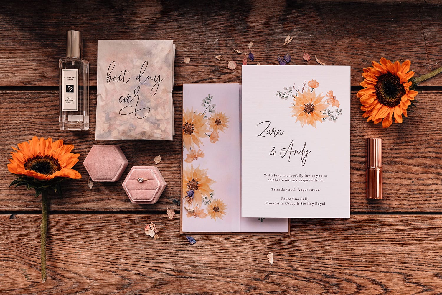 lay-flat photograph of wedding details, sunflowers and dusky pink